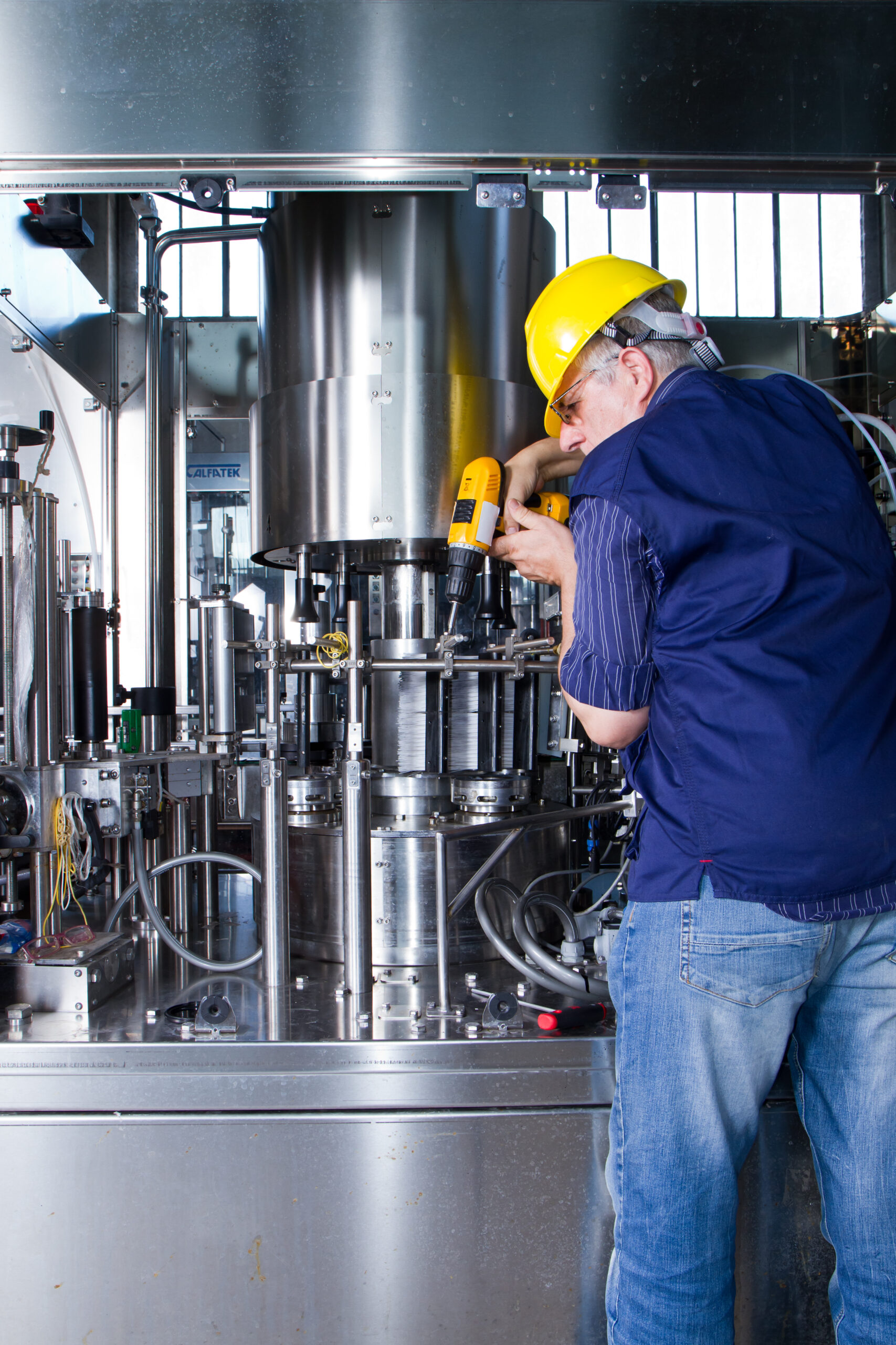 skilled worker while fixing a bottling plant during maintenance work